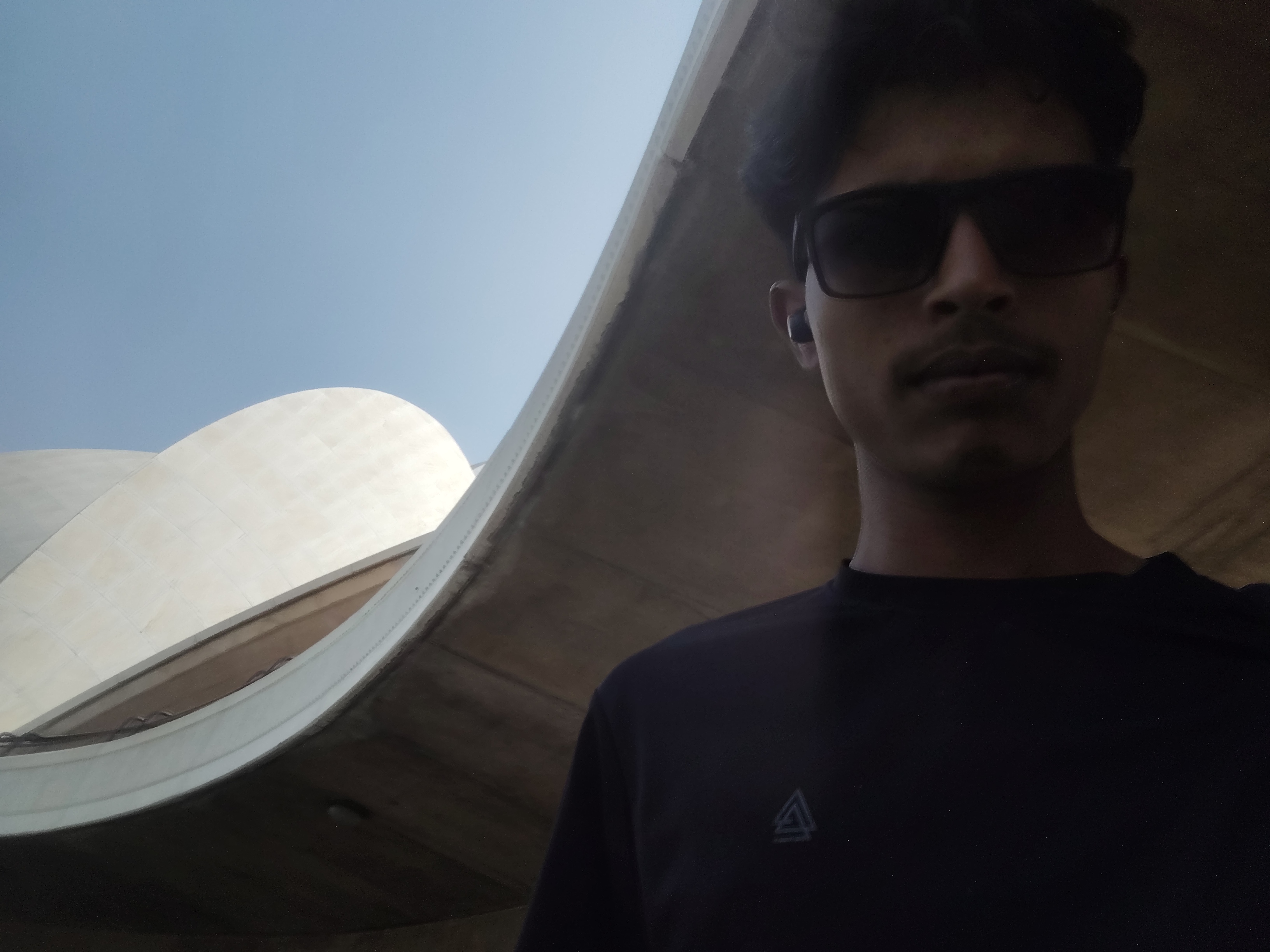 Low-angle selfie beneath the curved exterior of the Lotus Temple