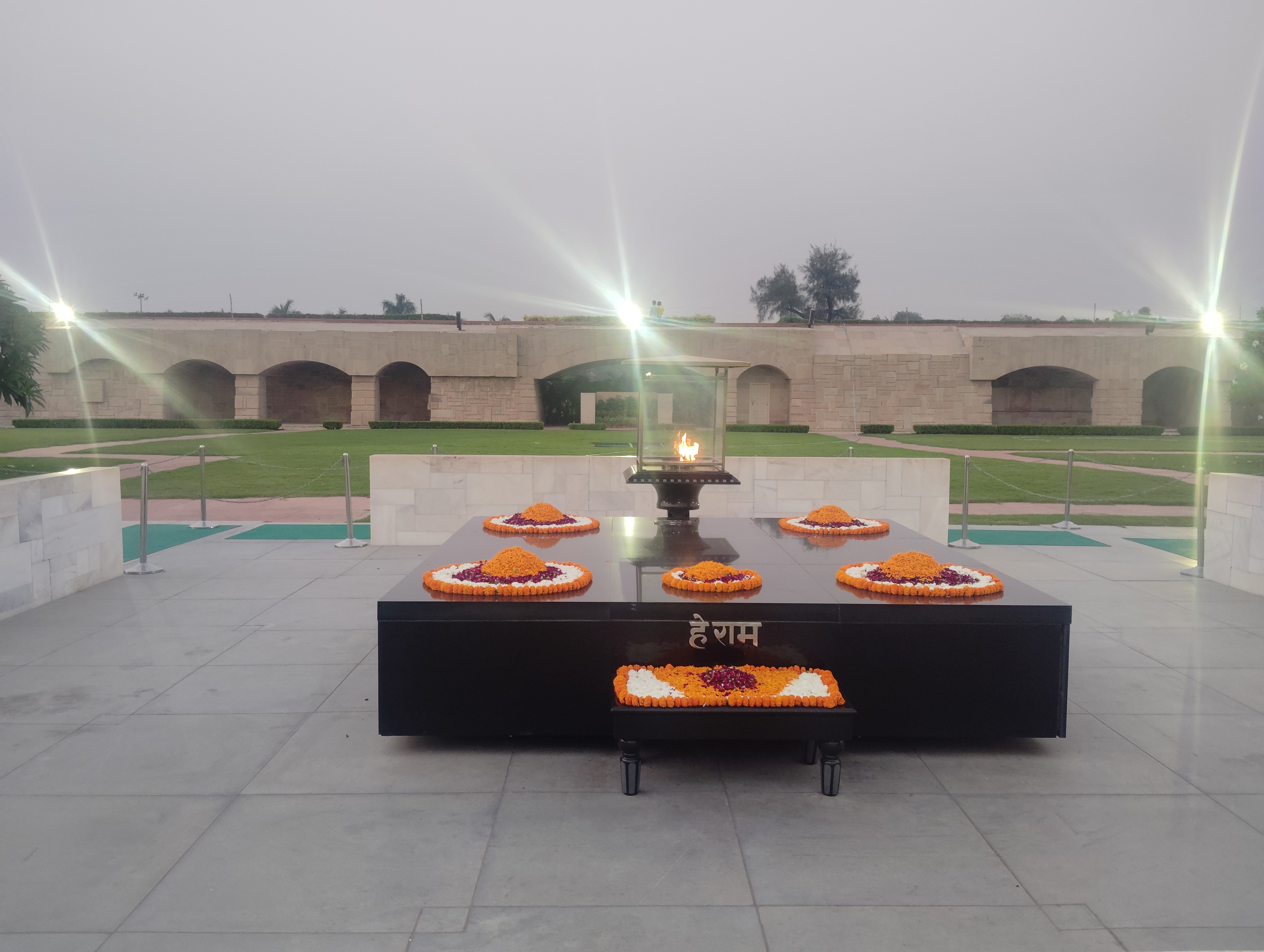 The flower-decorated memorial and eternal flame at Raj Ghat