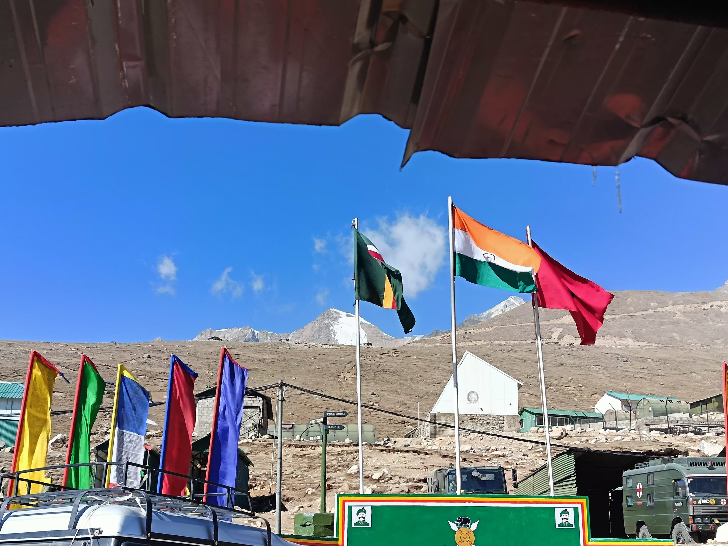 The Indian flag and colorful flags flying at a high-altitude Sikkim outpost