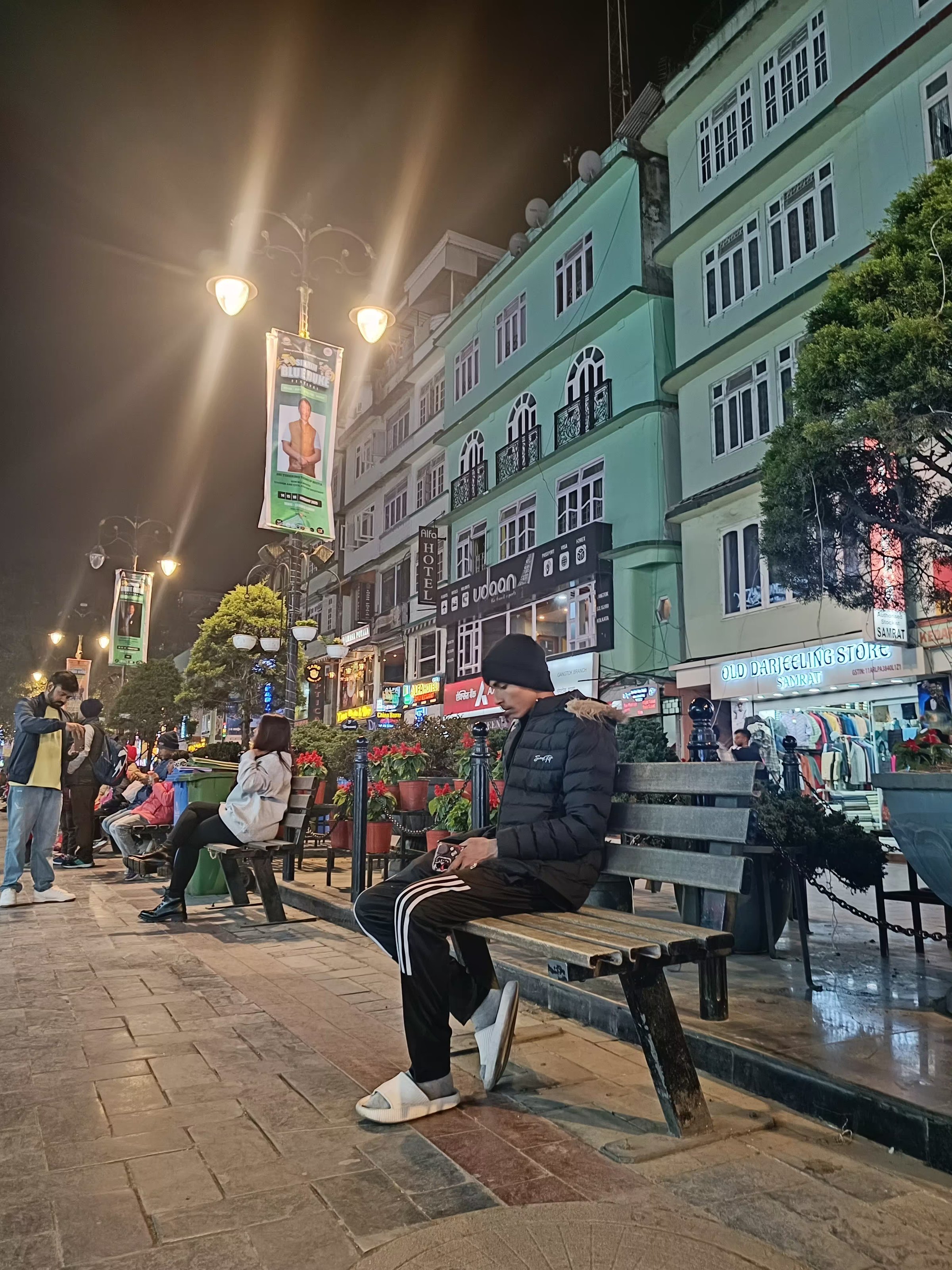 Ashish Alam Kabir sitting on a bench along the illuminated MG Marg in Gangtok