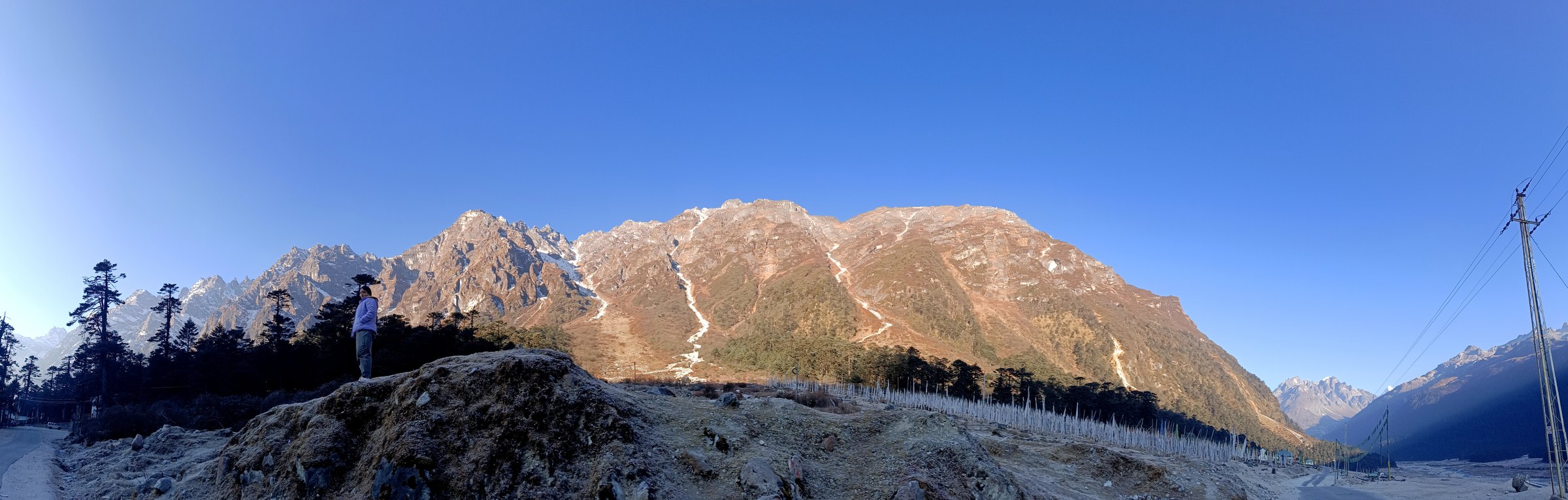 A panoramic sweep of a frosty valley and mountain range in North Sikkim
