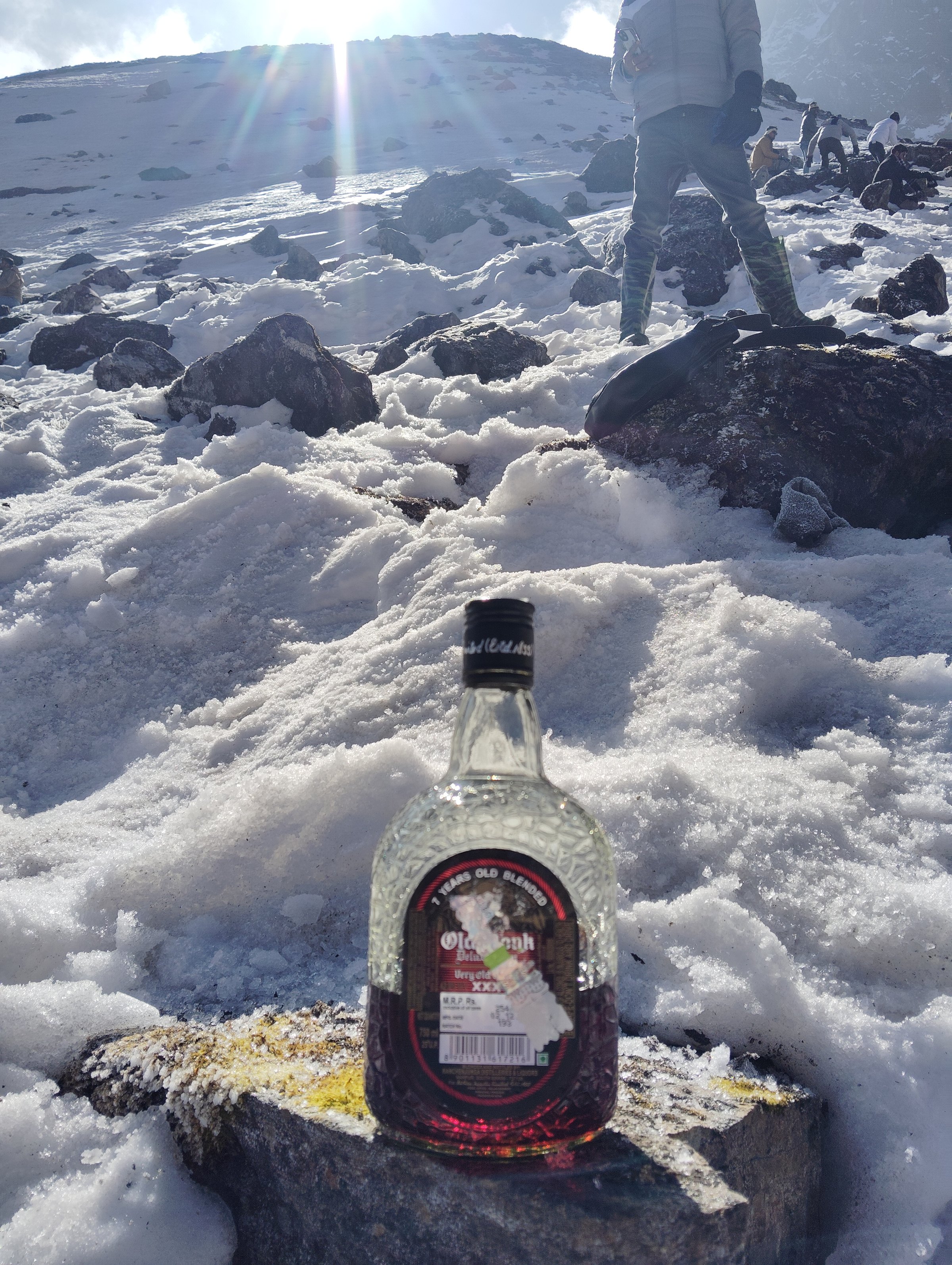 A keepsake bottle resting on a rock in a snowy mountain landscape
