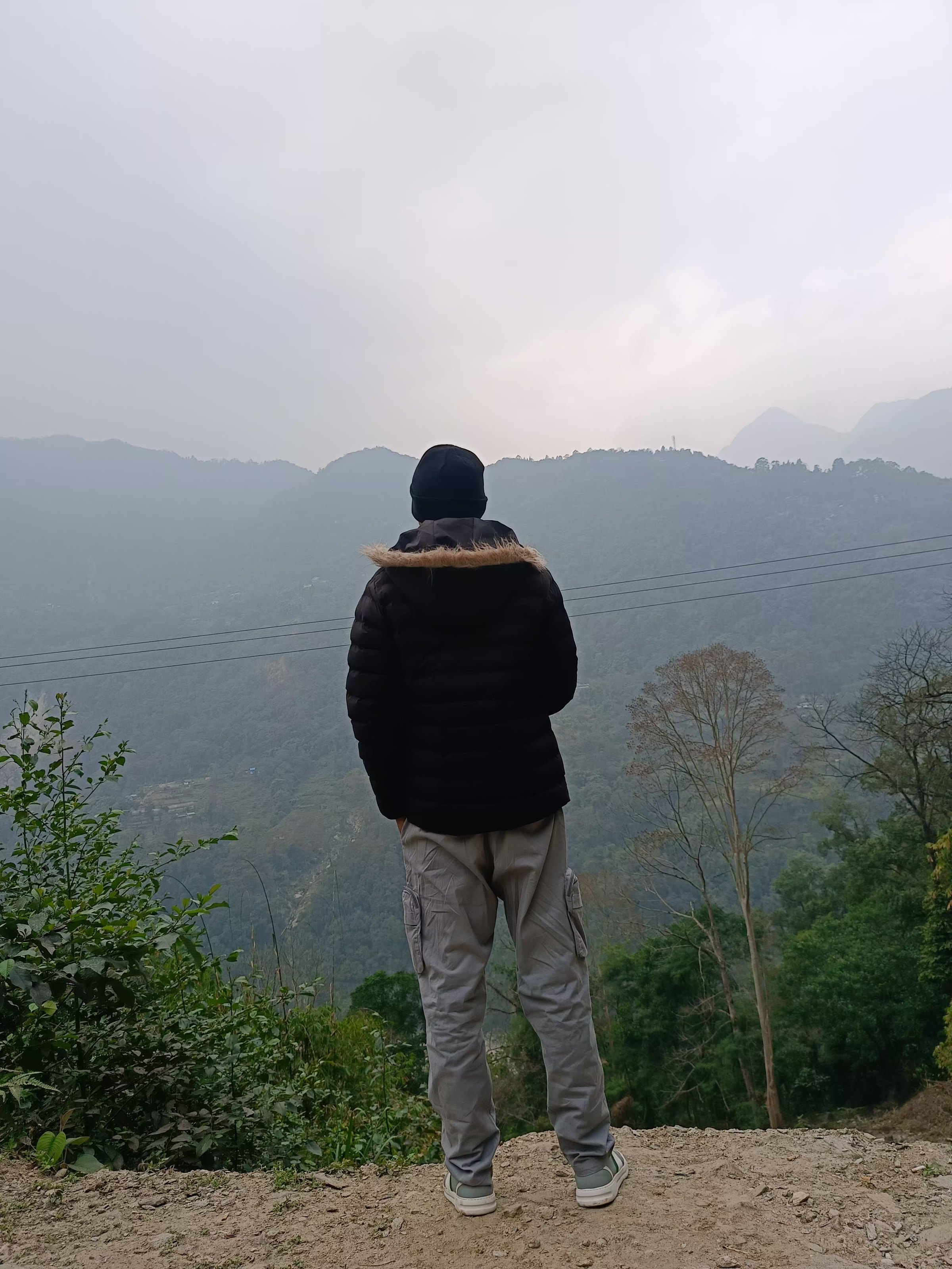 Ashish Alam Kabir looking across a misty mountain valley in Sikkim